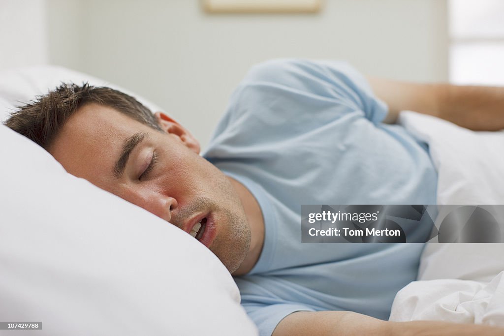 Sick man sleeping in bed