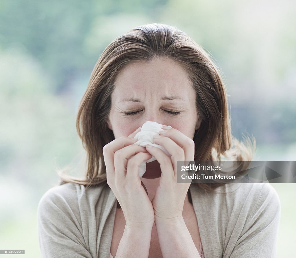 Sick woman wiping her nose