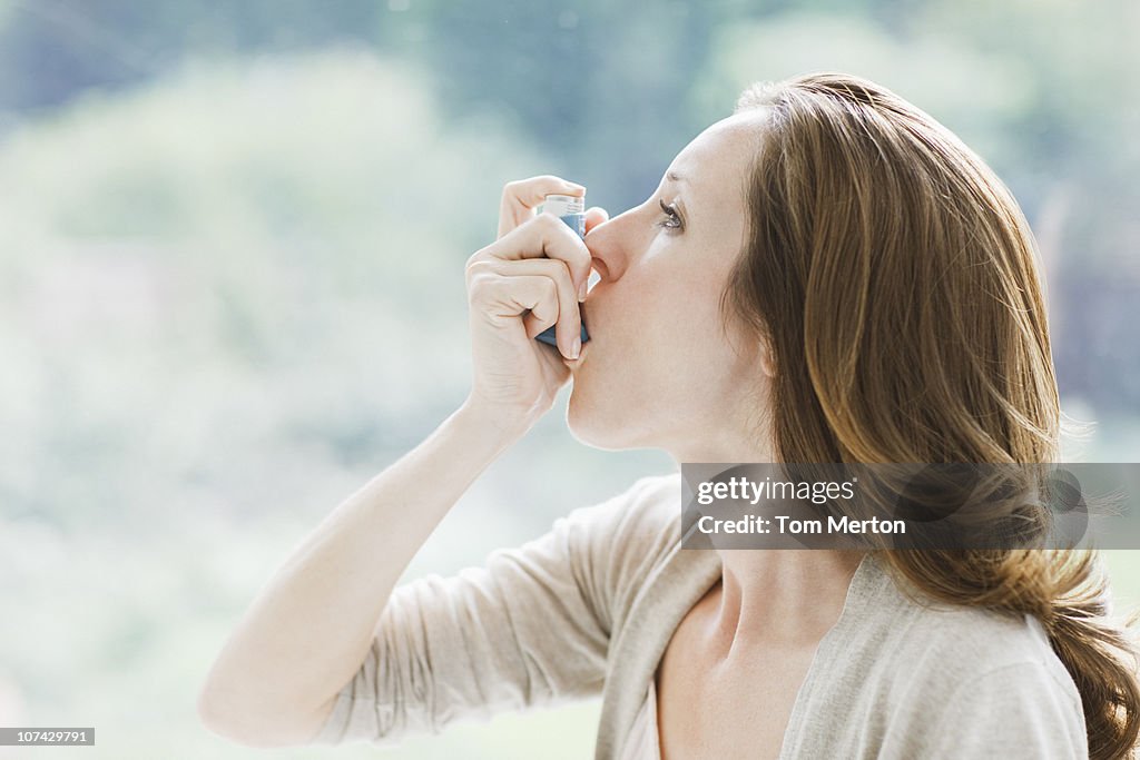 Mujer usando inhalador de asma