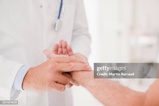 médecin prenant les patients cœur - prendre le pouls photos et images de collection