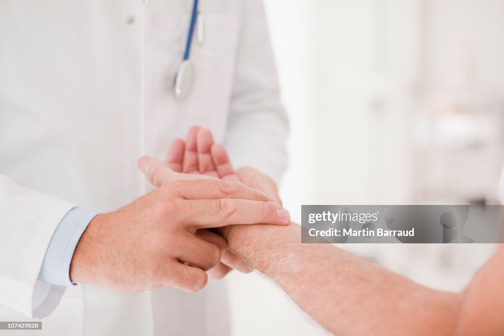 Doctor taking patients pulse