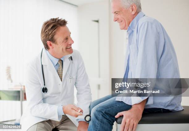 doctor checking patients reflexes in doctors office - doctor profile view stock pictures, royalty-free photos & images