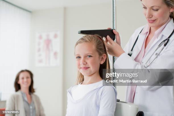 doctor measuring patients height in doctors office - doctor's office scale stock pictures, royalty-free photos & images