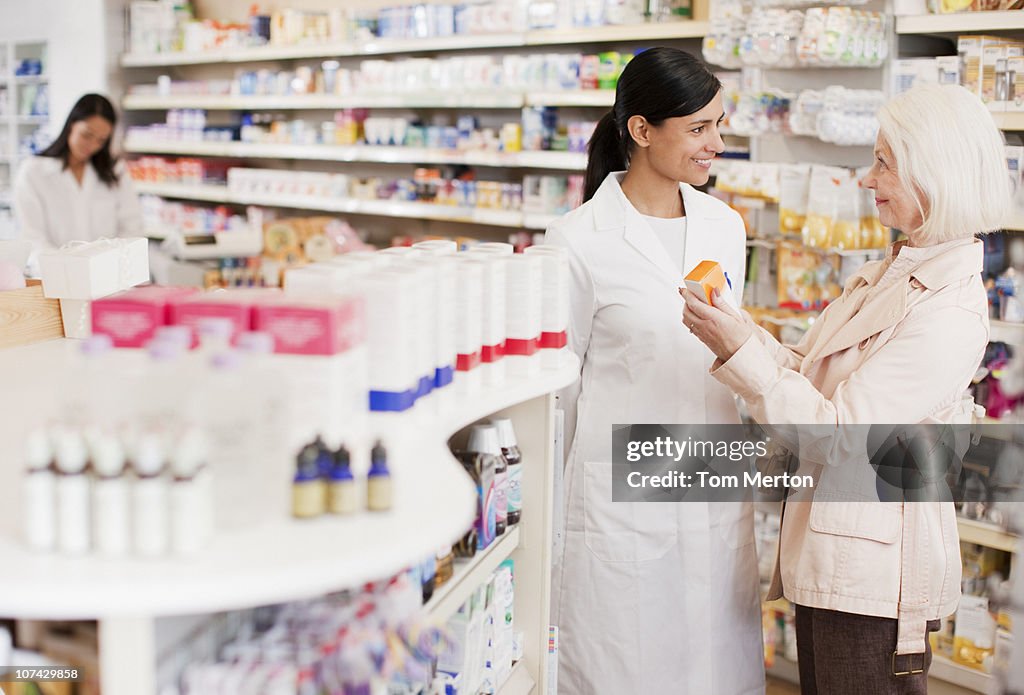 Pharmacist talking to customer in drug store