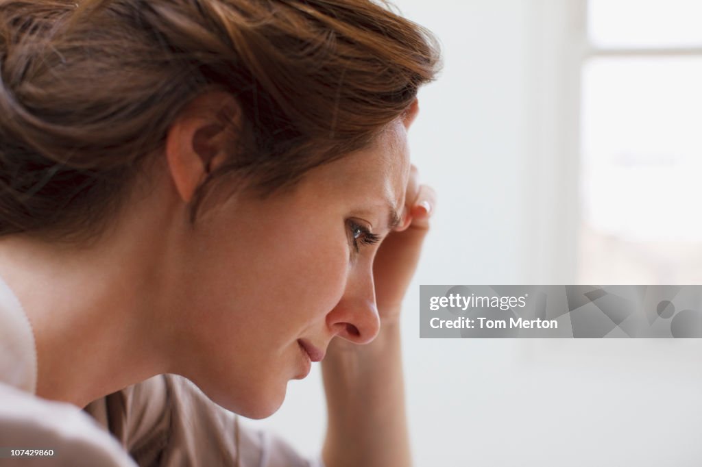 Depressed woman with head in hands