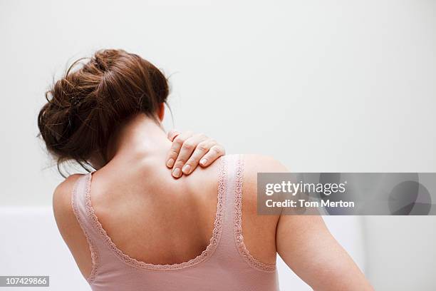 woman rubbing aching back - schouder stockfoto's en -beelden