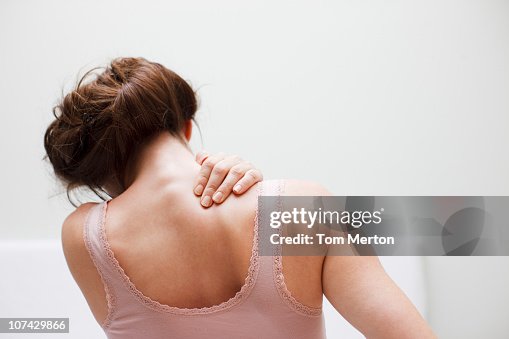 Woman rubbing aching back Woman rubbing aching back