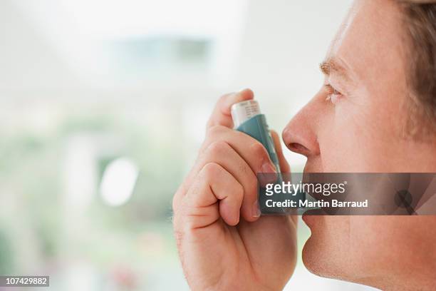 man about to use asthma inhaler - asthma in adults stock pictures, royalty-free photos & images