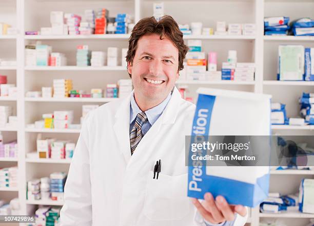 pharmacist holding prescription in drug store - filling prescription stock pictures, royalty-free photos & images