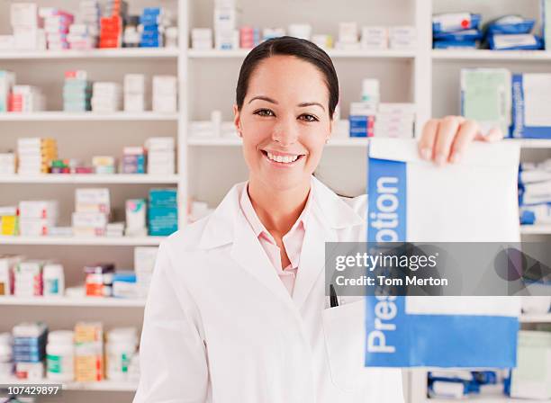 pharmacist holding prescription in drug store - prescription medicine stock pictures, royalty-free photos & images