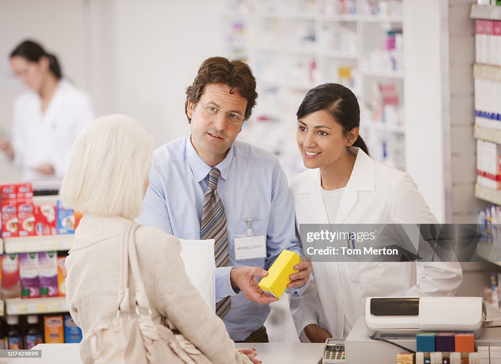 Pharmacists answering questions for customer in drug store