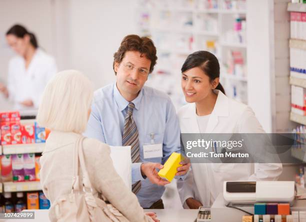 pharmacists answering questions for customer in drug store - store manager stock pictures, royalty-free photos & images