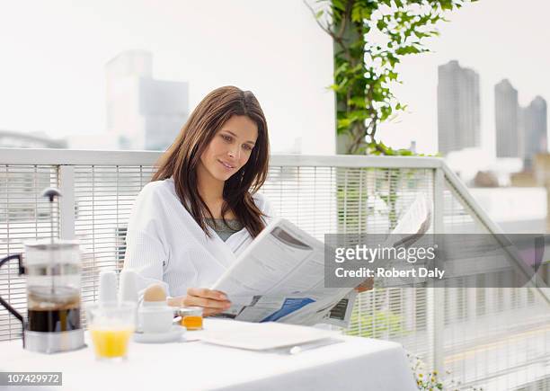 woman reading newspaper and having breakfast on balcony - newspaper luxury bildbanksfoton och bilder