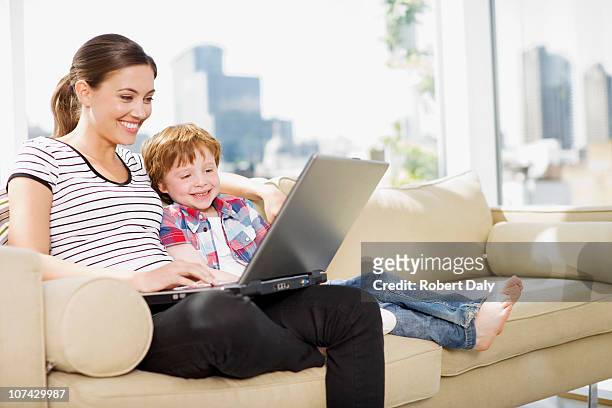 mother and son using laptop in living room - bare feet stock pictures, royalty-free photos & images