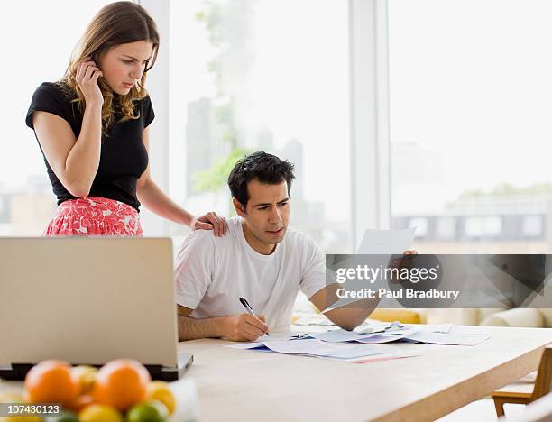 concerned couple paying bills together - trump prohibits purchase of debts owed to venezuela and pdvsa stockfoto's en -beelden