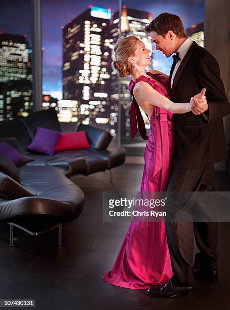 elegant couple dancing in living room - evening gown stock pictures, royalty-free photos & images