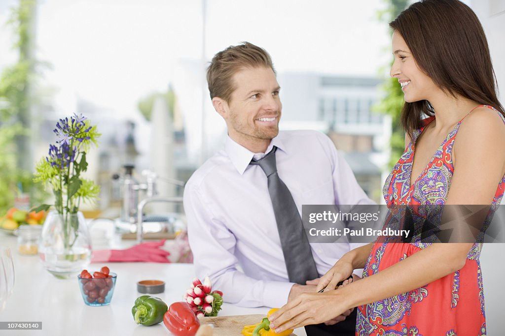 Parlando al marito moglie mentre tagli le verdure in cucina