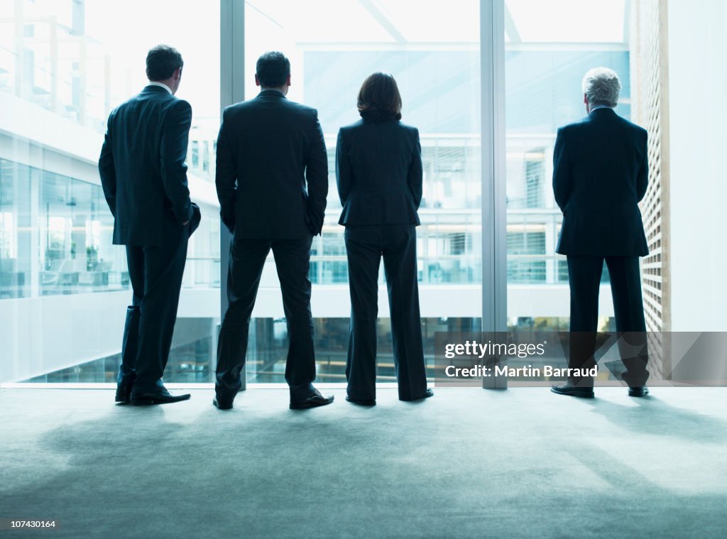 Business persone guardare fuori parete in vetro insieme