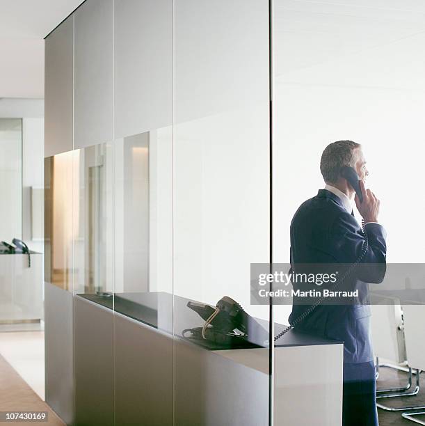 hombre de negocios hablando por teléfono celular en la sala de conferencias - telefono fijo fotografías e imágenes de stock