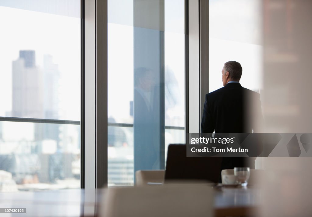 Businessman looking out conference room window