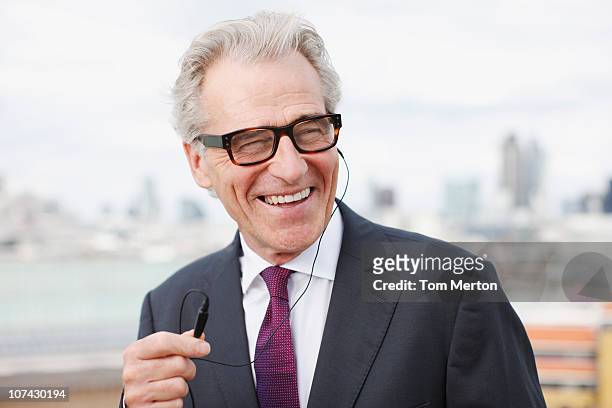 smiling businessman using cell phone hands-free device - old man laughing and glasses stock pictures, royalty-free photos & images