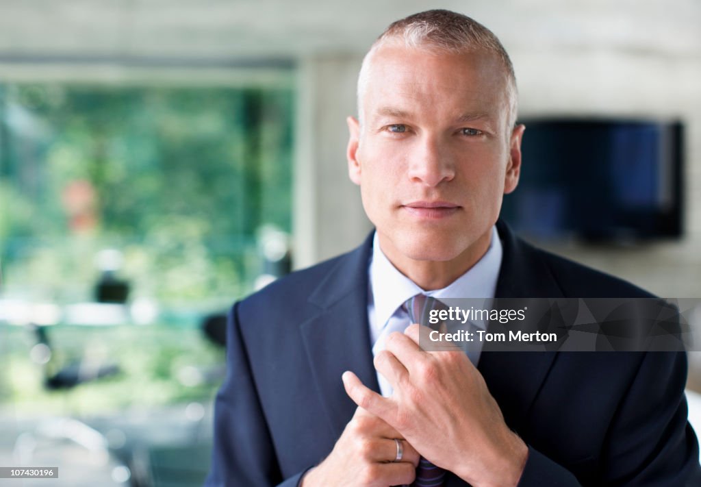 Businessman adjusting necktie