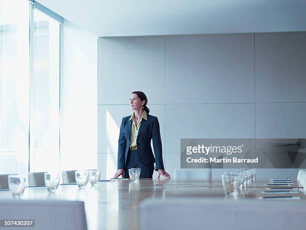 donna d'affari in piedi da solo in sala conferenze - sala conferenze foto e immagini stock