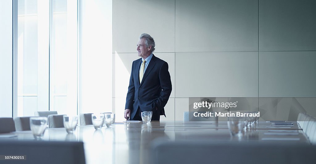 Businessman standing alone in conference room