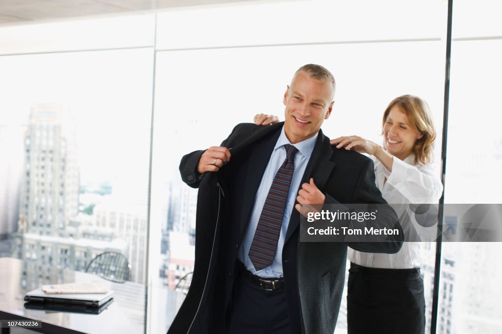 Geschäftsfrau unterstützt co-worker auf Mantel