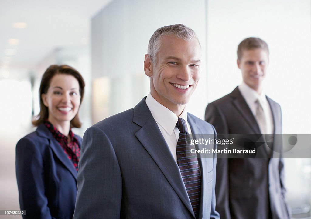 Smiling business people standing in office