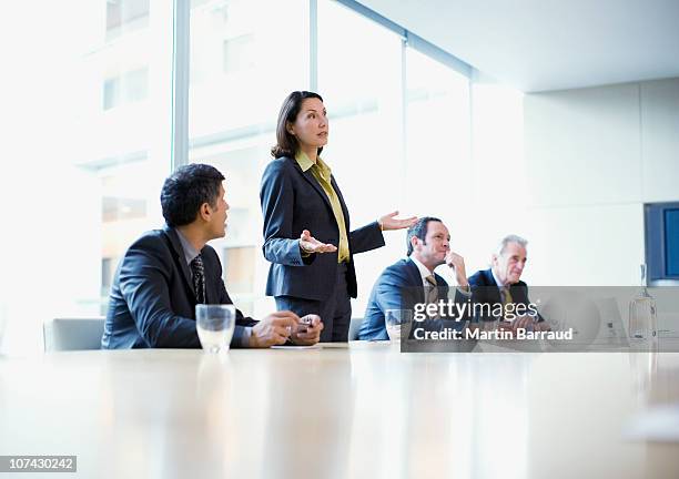 businesswoman giving presentation in conference room - persuasion business stock pictures, royalty-free photos & images