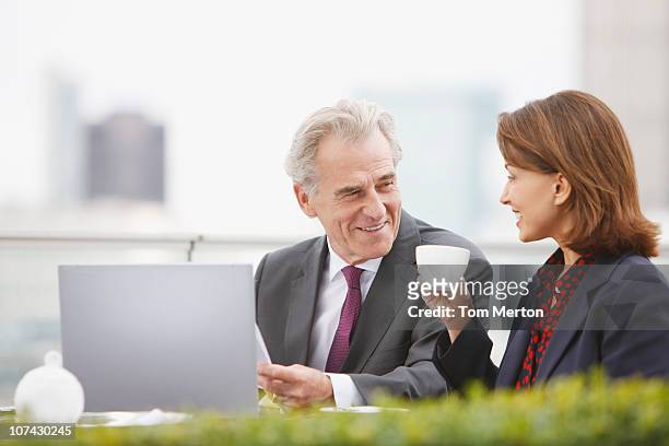 business people drinking coffee and working outdoors - senior manager stock pictures, royalty-free photos & images