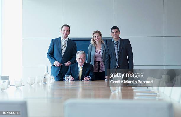 uomini d'affari in piedi insieme in una sala conferenze - four people foto e immagini stock