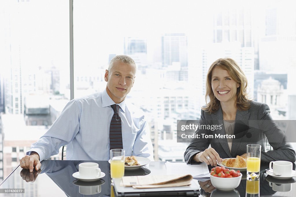 Pessoas de negócios sorridente tomando café-da-manhã
