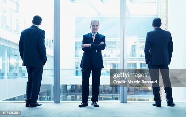 businessmen standing near glass wall in office - group of businesspeople standing low angle view stock pictures, royalty-free photos & images