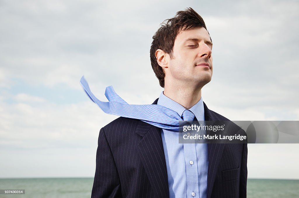 Wind blowing businessmans necktie near ocean