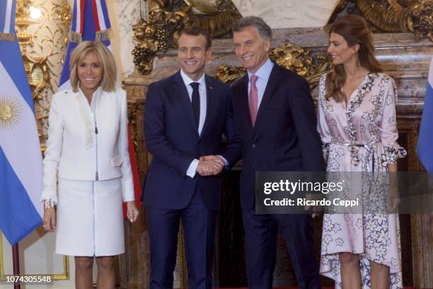 President of France Emmanuel Macron shakes hands with President of Argentina Mauricio Macri next to First Lady of France Brigitte Macron and First...