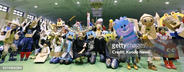 People wearing anime character costumes made of cardboard pose for photos at Cardboard Cosplay Festival in Aomori, northeastern Japan, on Dec. 16,...