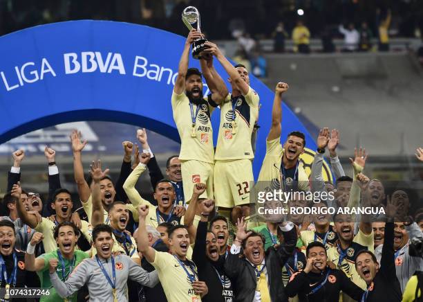 America's players celebrate with the trophy after defeating Cruz Azul to win the Mexican Apertura Tournament football final at the Azteca stadium in...