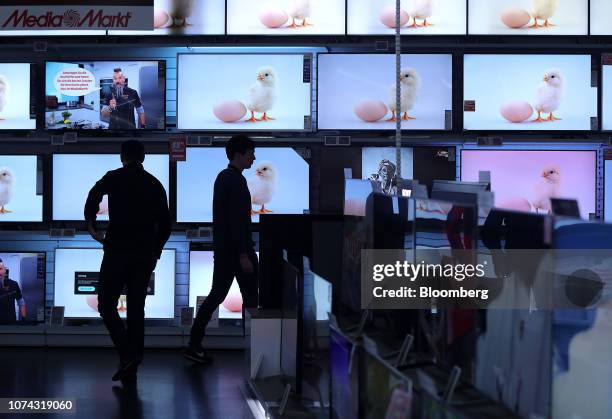 Customers browse flat screen televisions inside a Media Markt electronic goods store, operated by Ceconomy AG, in Berlin, Germany, on Monday, Dec....