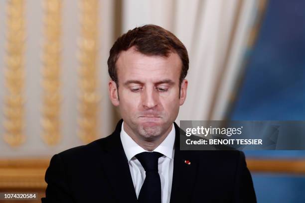 French President Emmanuel Macron reacts during a joint press conference with President of Burkina Faso at the Elysee Palace in Paris, on December 17...