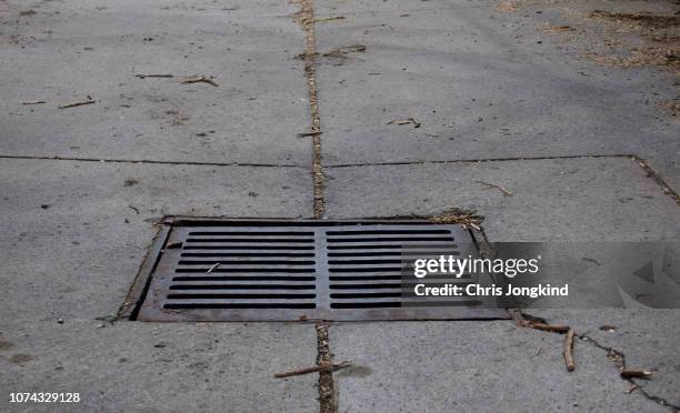 metal drain cover on street - マンホール ストックフォトと画像