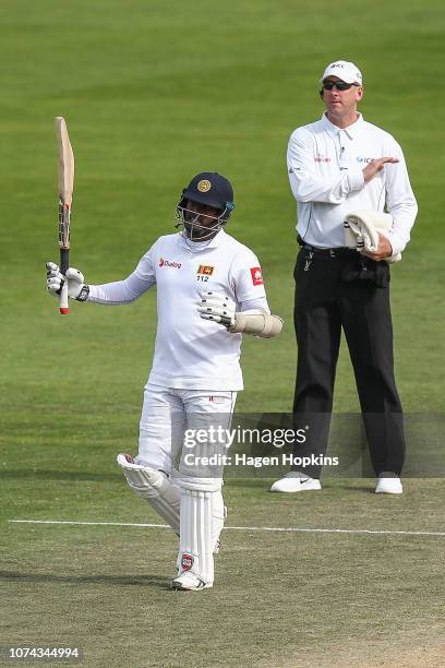 Angelo Mathews of Sri Lanka celebrates his century while umpire Michael Gough of England signals a boundary during day four of the First Test match...