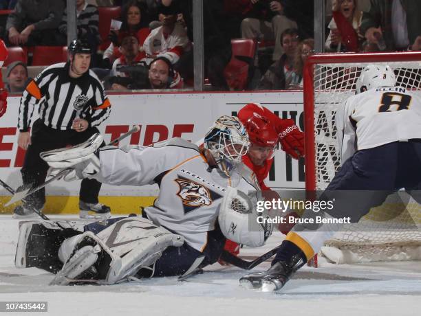 Anders Lindback of the Nashville Predators makes the save as Darren Helm of the Detroit Red Wings looks for the rebound at the Joe Louis Arena on...