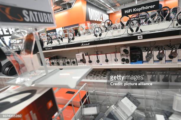 December 2018, North Rhine-Westphalia, Köln: Headphones stand in a market of retail chain "Saturn" on offers to try on the shelves. Photo: Henning...