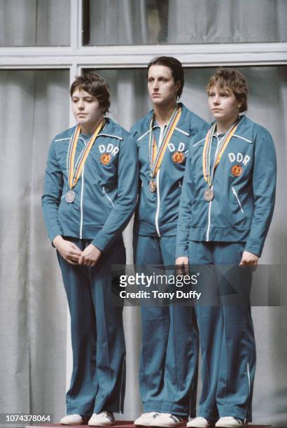 Barbara Krause of East Germany stands on the podium with her gold medal together with silver medallist Ines Diers and bronze medallist Carmela...