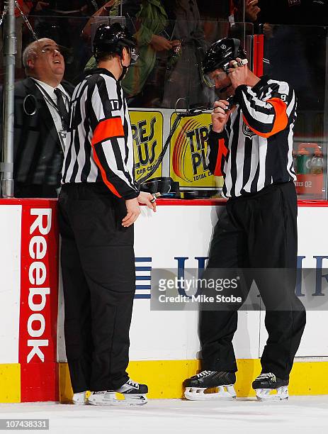 Referee Dan O'Rourke reviews Mike Richards of the Philadelphia Flyers overtime goal after a replay showed time expired an instant before the puck...