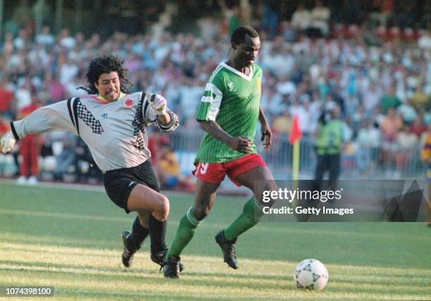 Cameroon striker Roger Milla walks the ball into the empty net to score the winning goal after dispossesing Colombian goalkeeper Rene Higuita of the...