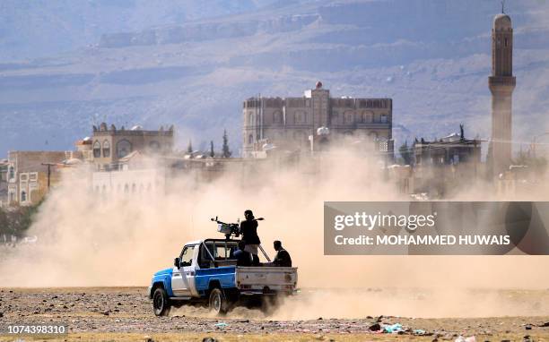 Yemeni men stand at the back of an armed pick up as poeple in the capital Sanaa to show their support to the Shiite Huthi movement against the...