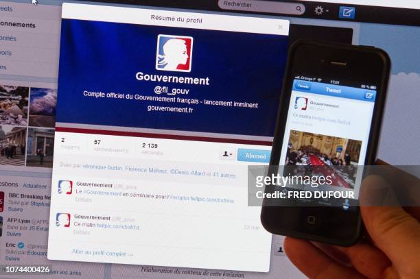 Picture taken on January 4, 2013 in Paris of a person presenting his smartphone next to a computer, both connected on the French governement official...